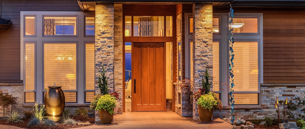 Outside front door of Modern Mountain house with fountain. Silhouette shades seen inside the home.